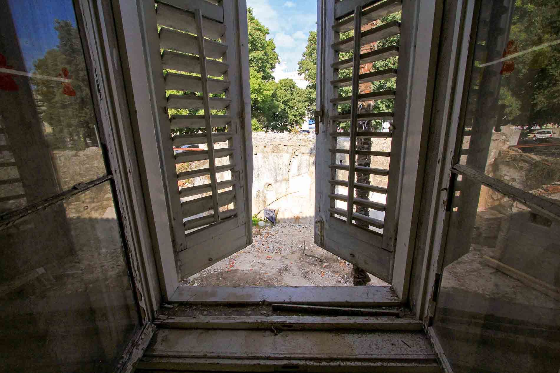 A view from an old window onto the cleared courtyard during the initial phase of the Almayer Hotel's reconstruction in 2015.