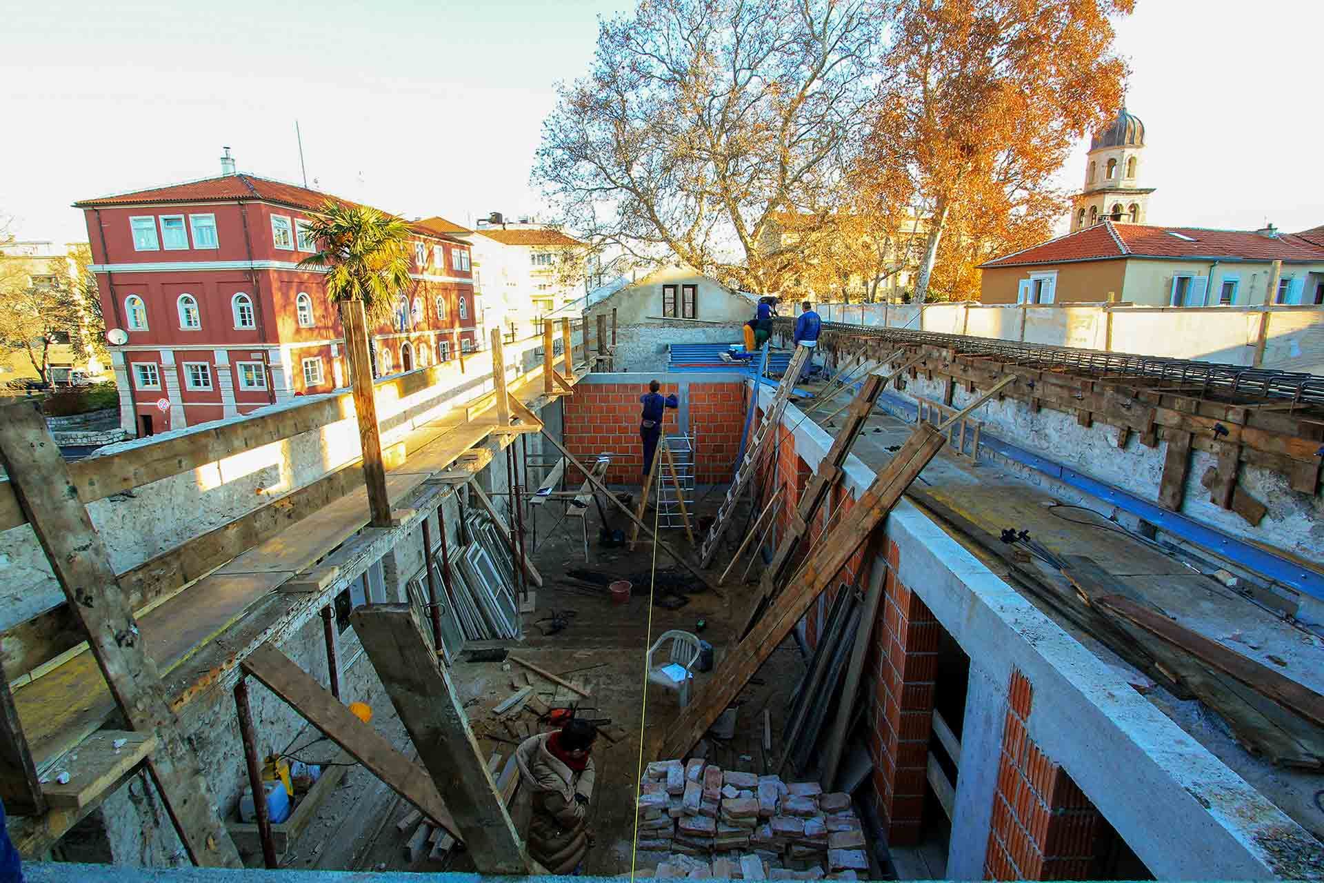 A photograph of the future Almayer Hotel, showing the building without a roof during the demanding reconstruction of the cornice and roofing in 2016