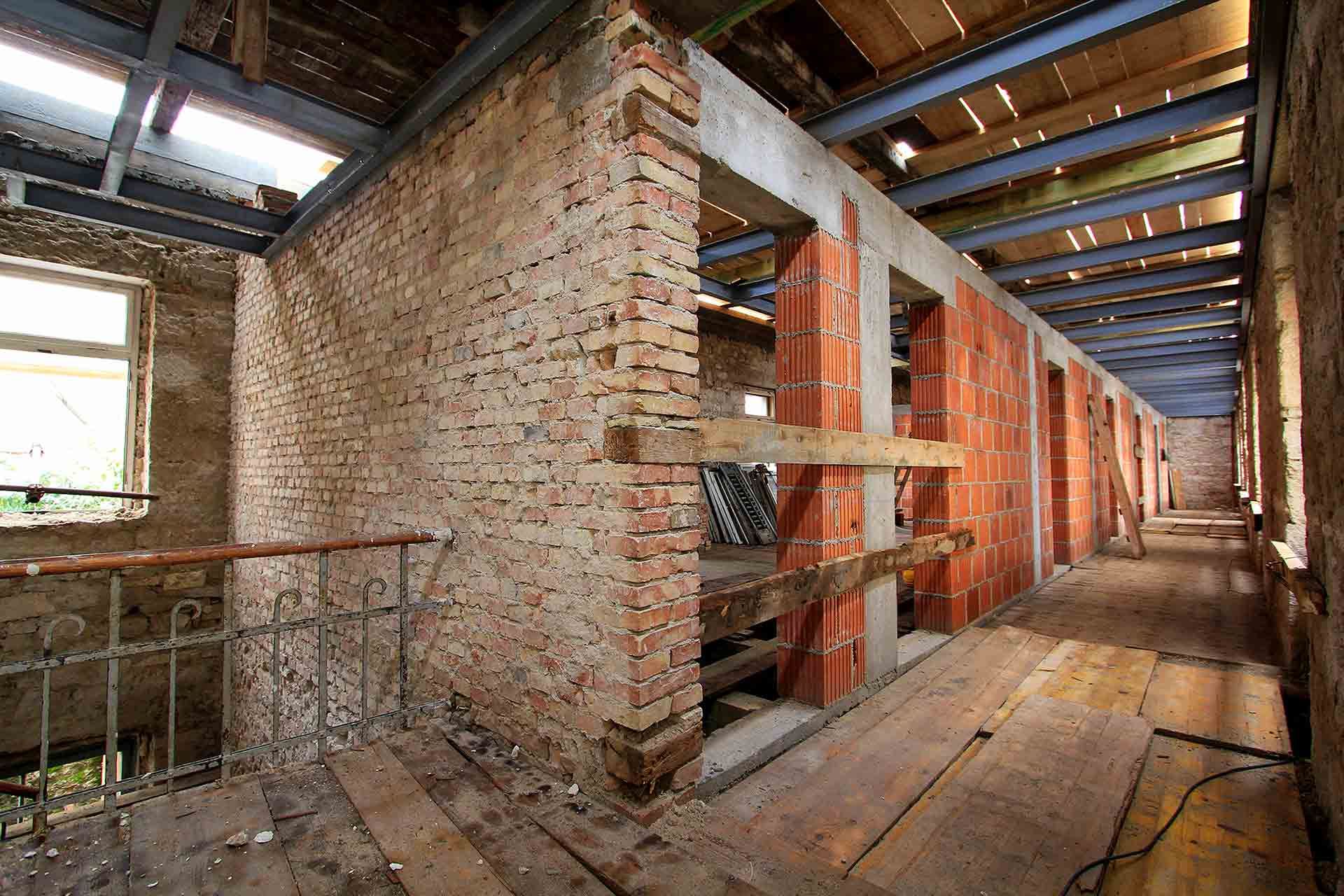 A view of the staircase and hallway on the first floor of the future hotel during the 2016 reconstruction reveals the scope of the work undertaken
