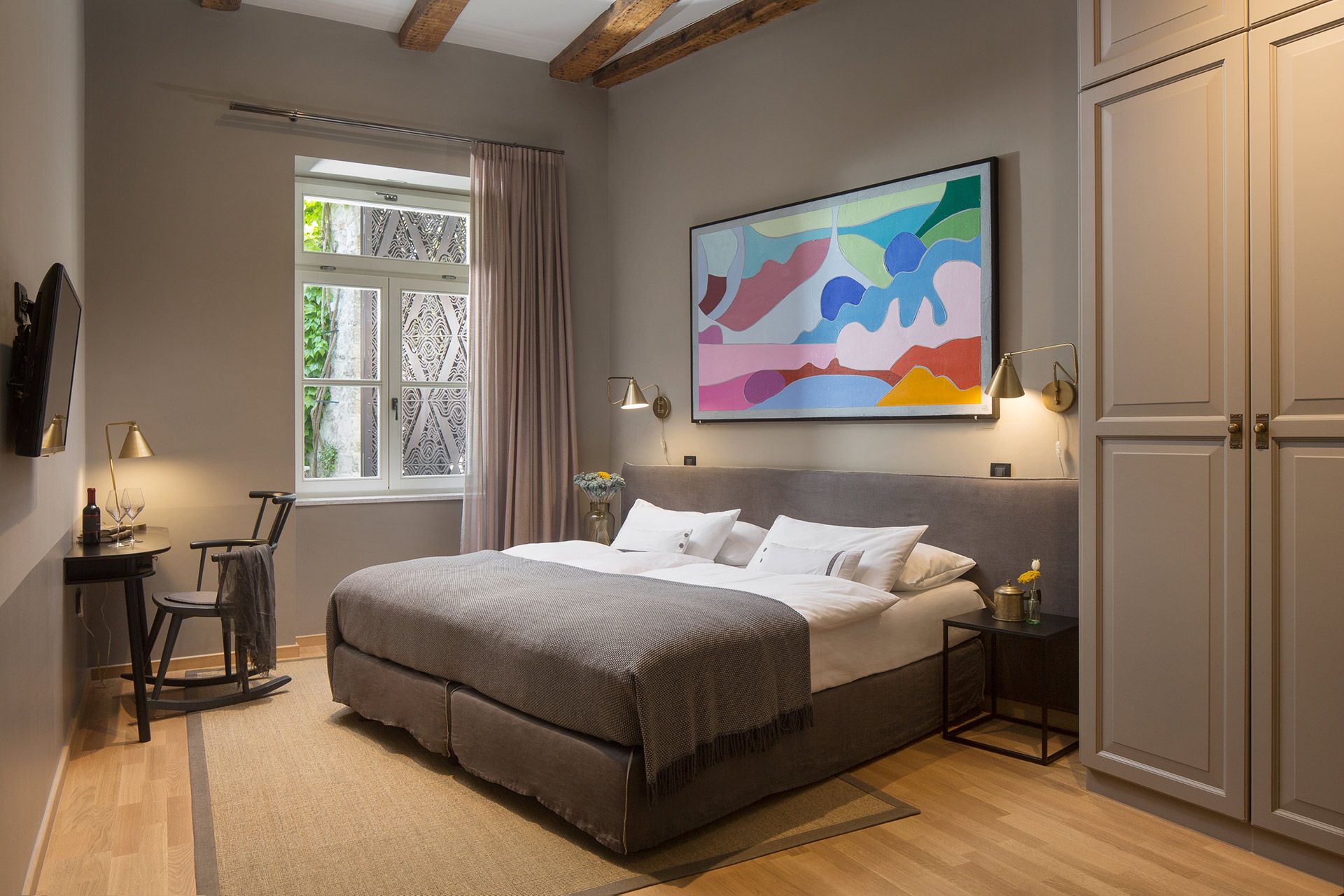 Spacious Almayer hotel’s standard double room Garbin with its king-size bed, painting, and bright window