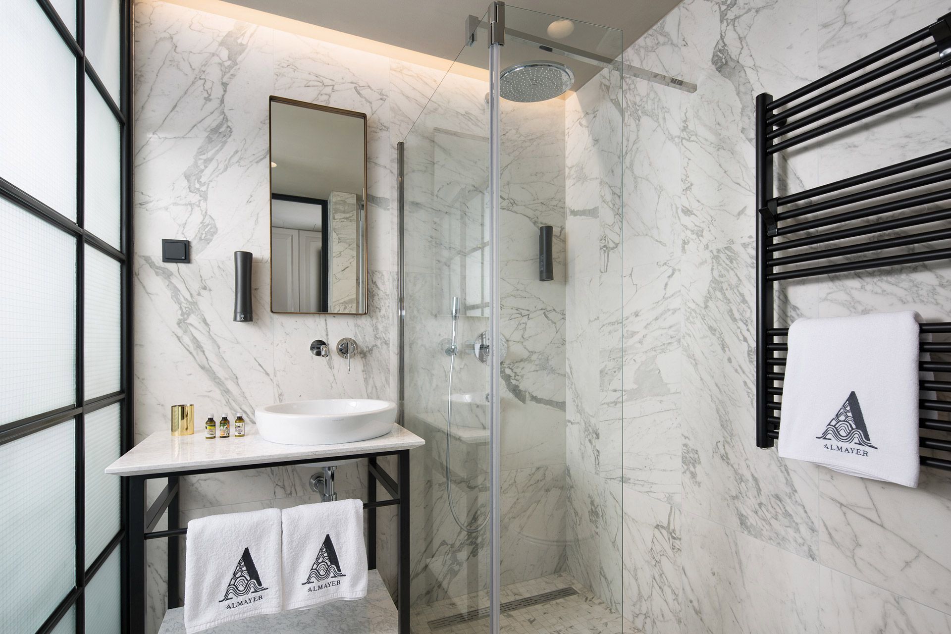 Marble tiles bathroom with steel and glass partition wall in Almayer hotel’s deluxe mezzanine double rooms 