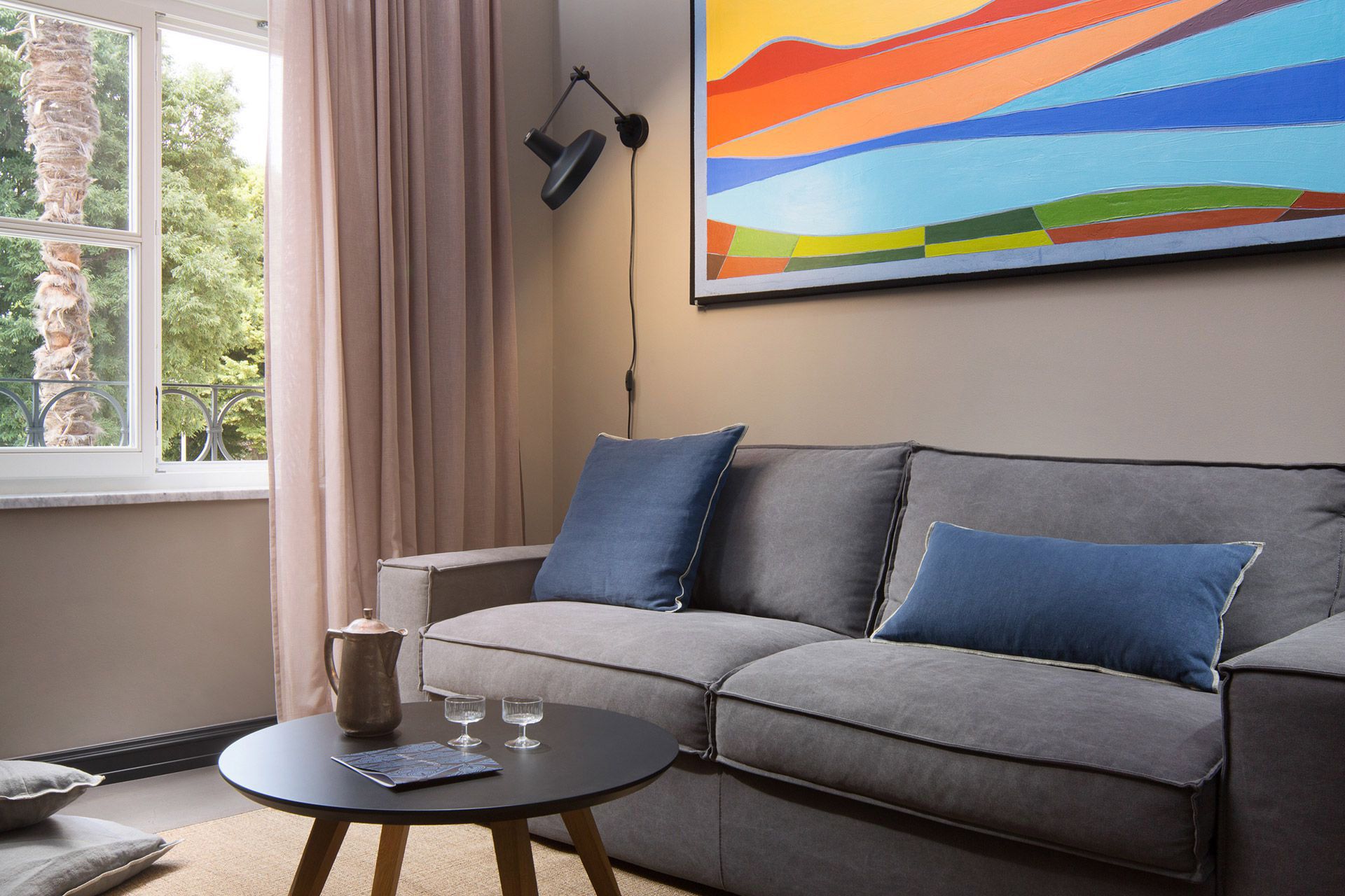 Living area with sofa extendable to queen-size bed in Almayer hotel’s deluxe mezzanine double room