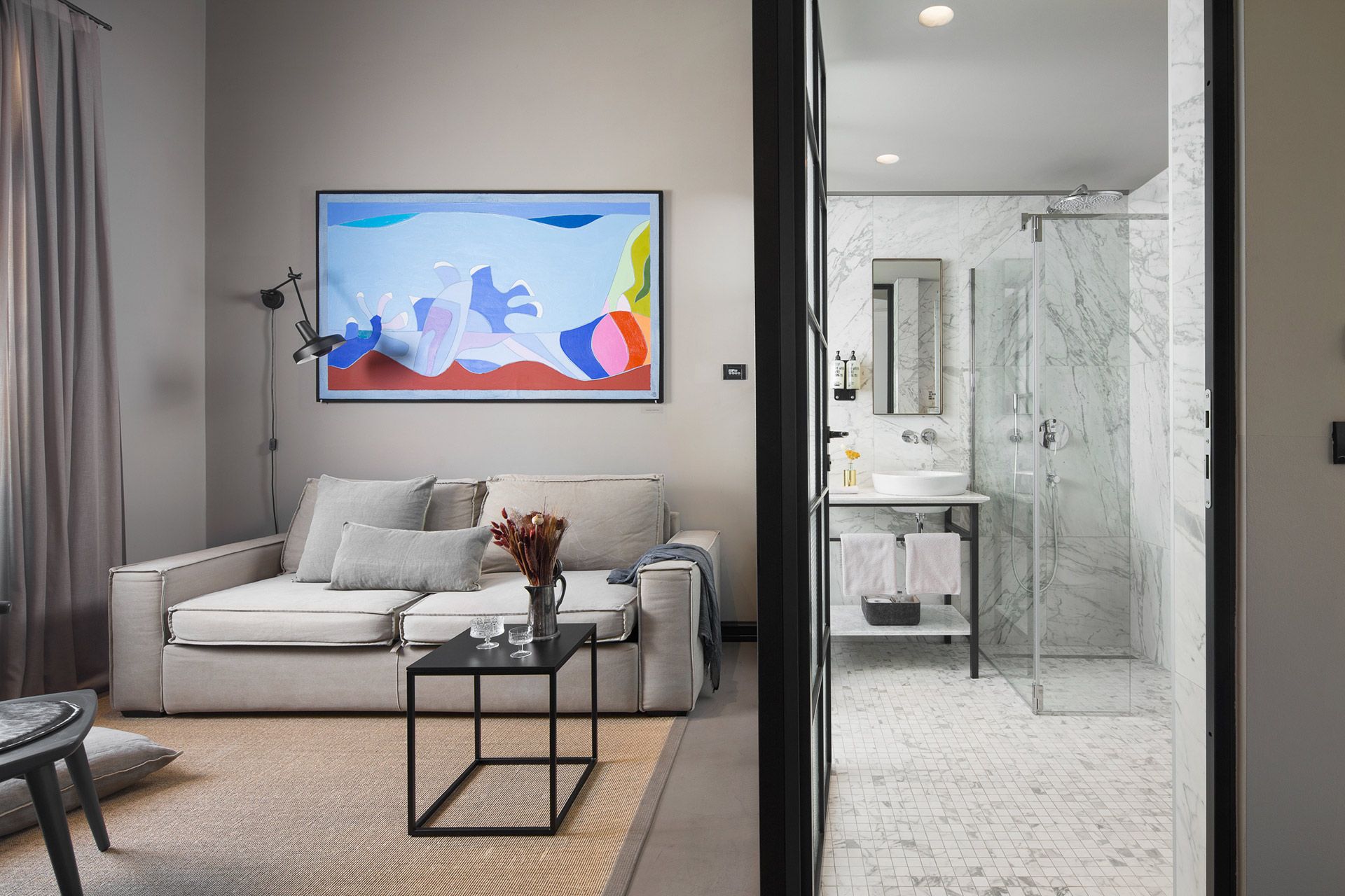 The interior design of the living area and bathroom in Almayer hotel’s deluxe mezzanine double room 