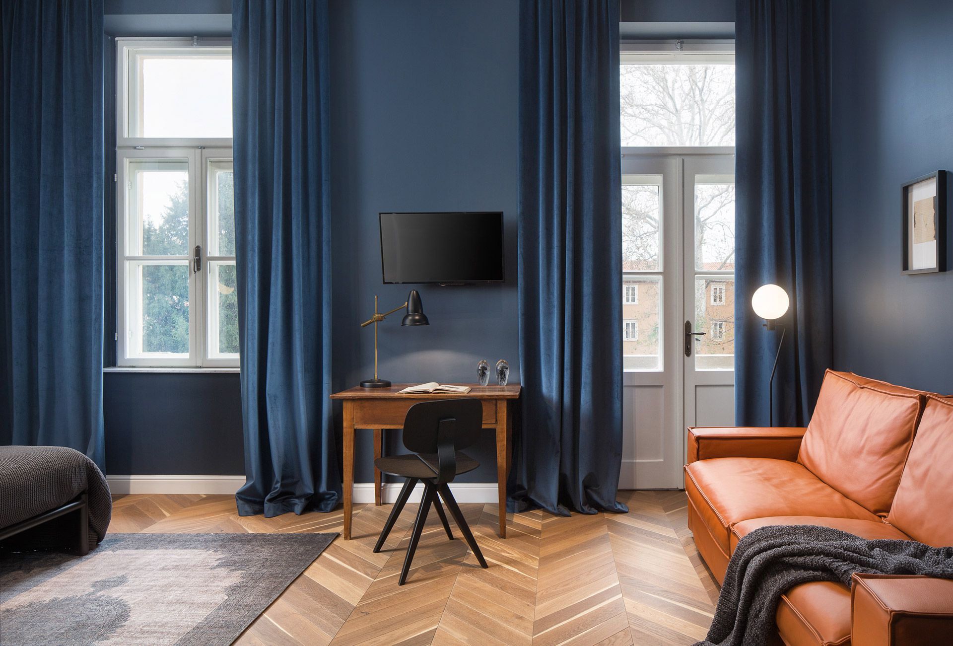 Living area with sofa extendable to queen-size bed in Almayer hotel’s deluxe double room in dependance